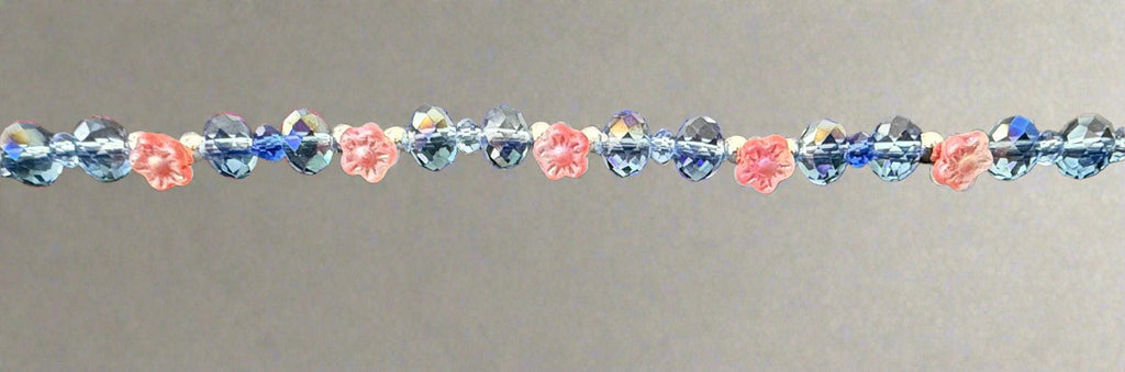 Beaded bracelet with pink and blue beads on a textured gray background