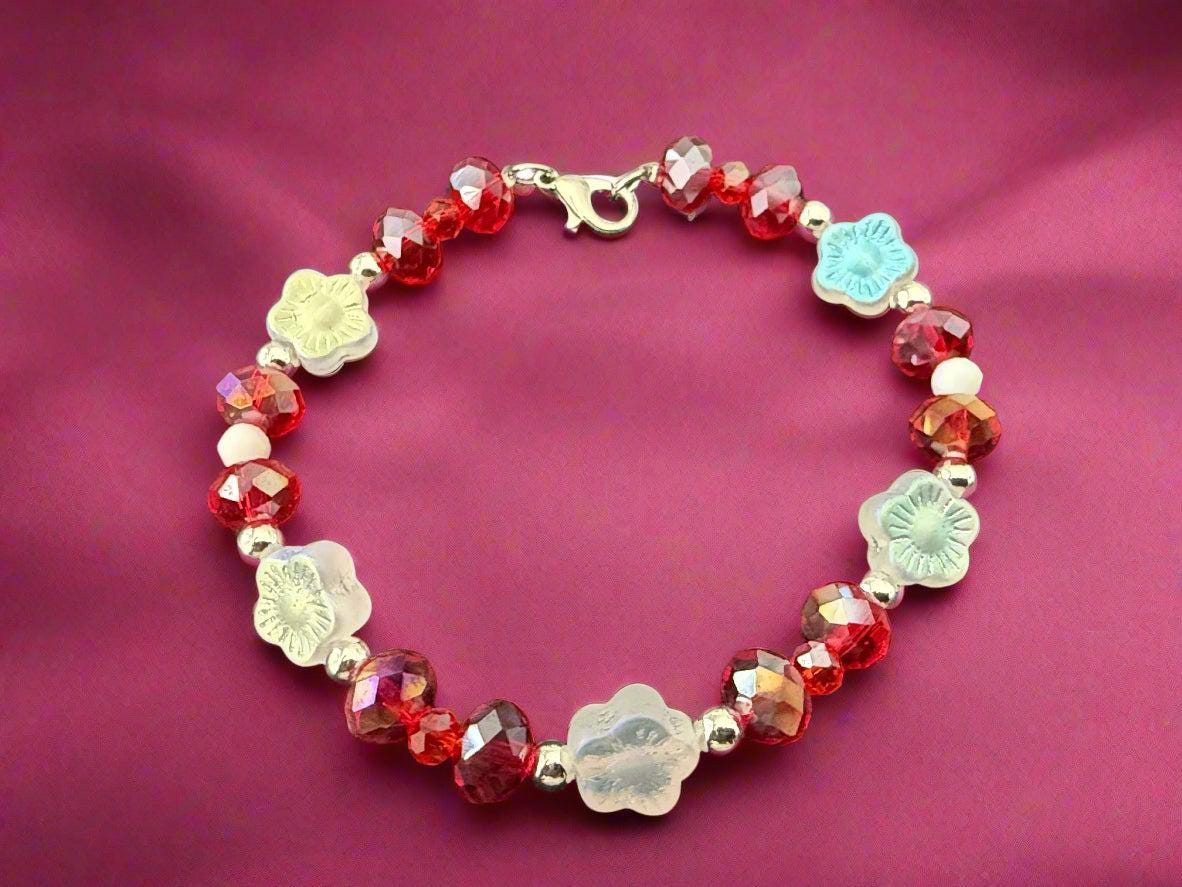 Beaded bracelet with red, white, and light blue beads on a dark background