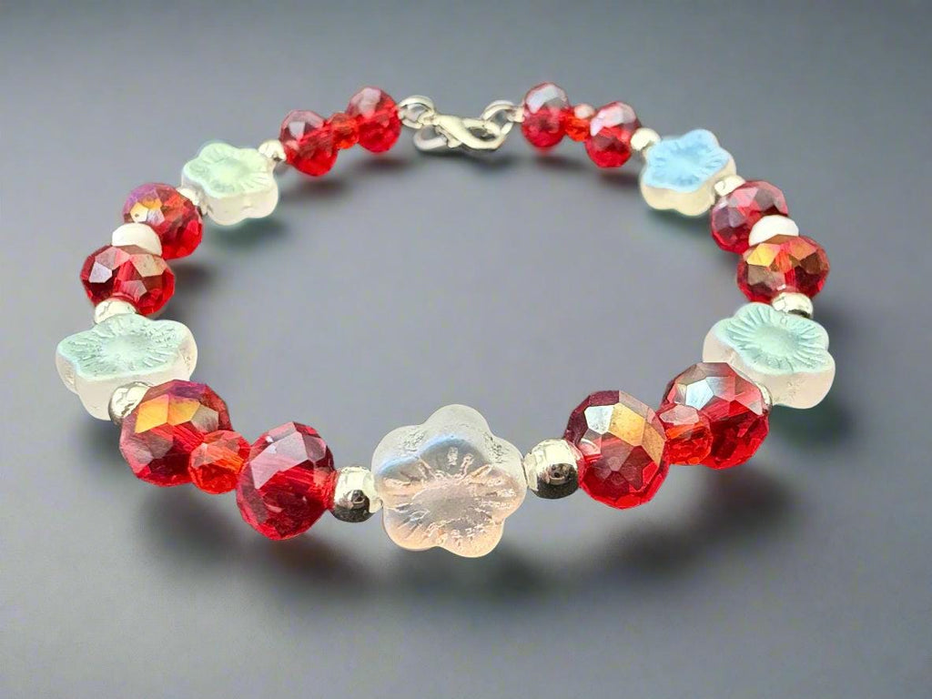 Bracelet with red and clear beads on a dark background