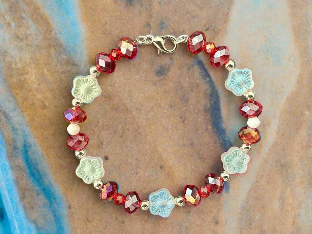 Bracelet with red and clear beads on a black textured background