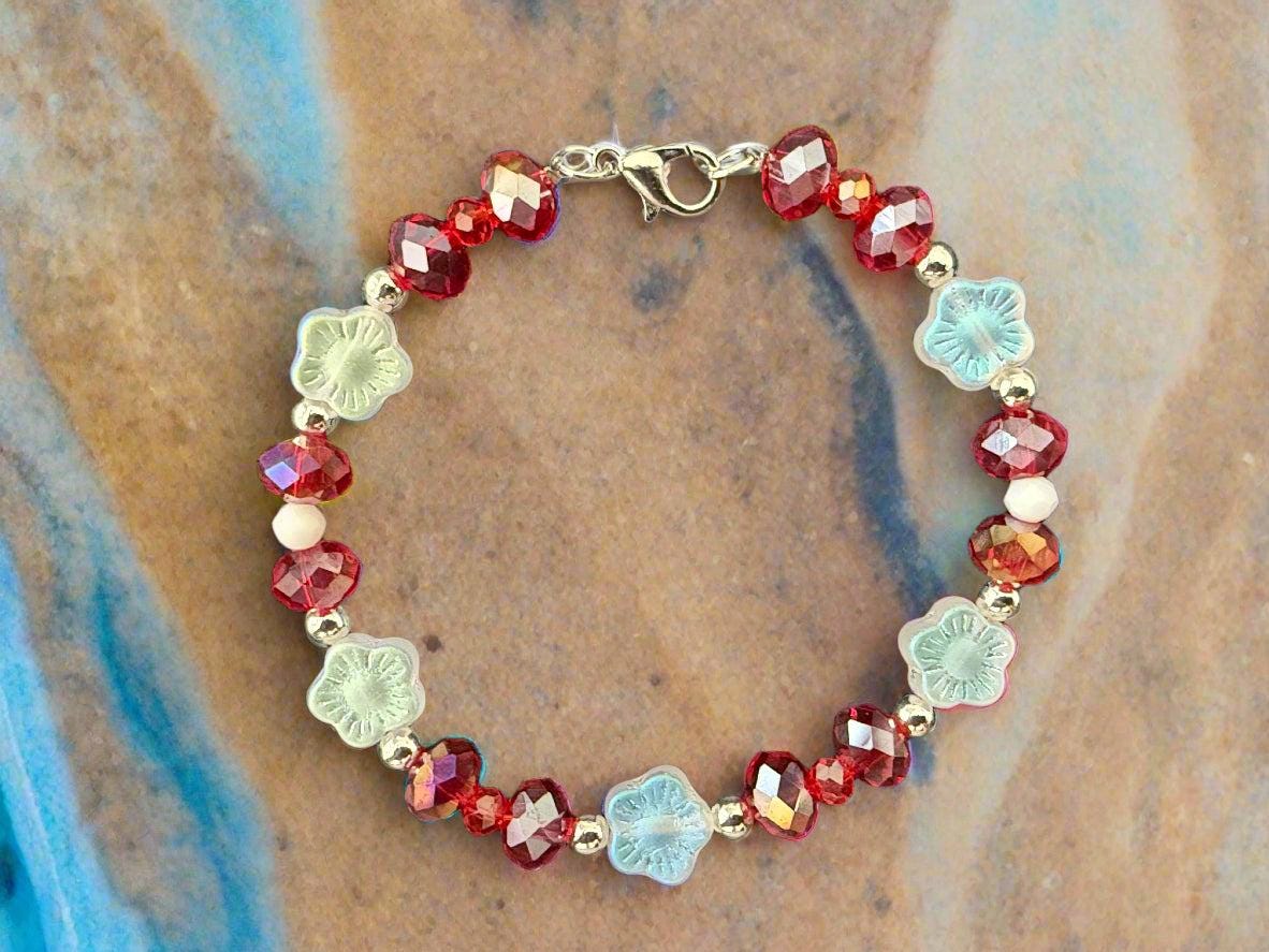 Bracelet with red and clear beads on a black textured background