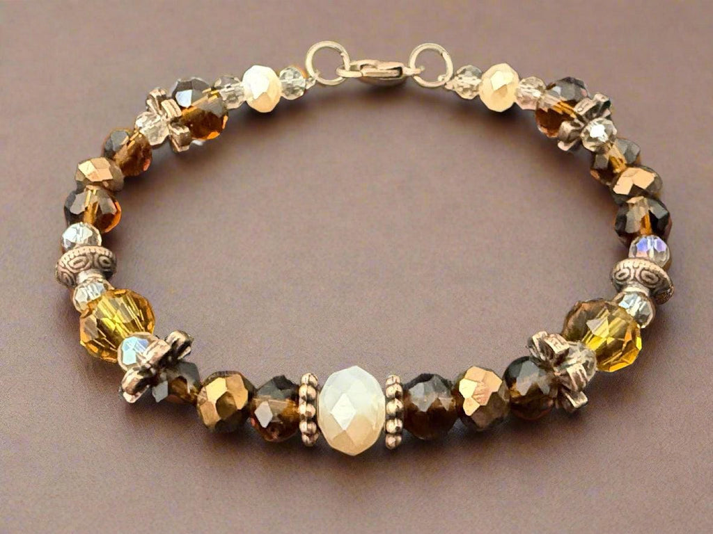 Beaded bracelet with brown and gold stones on a dark fabric background