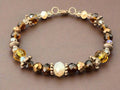 Beaded bracelet with brown and gold stones on a dark fabric background