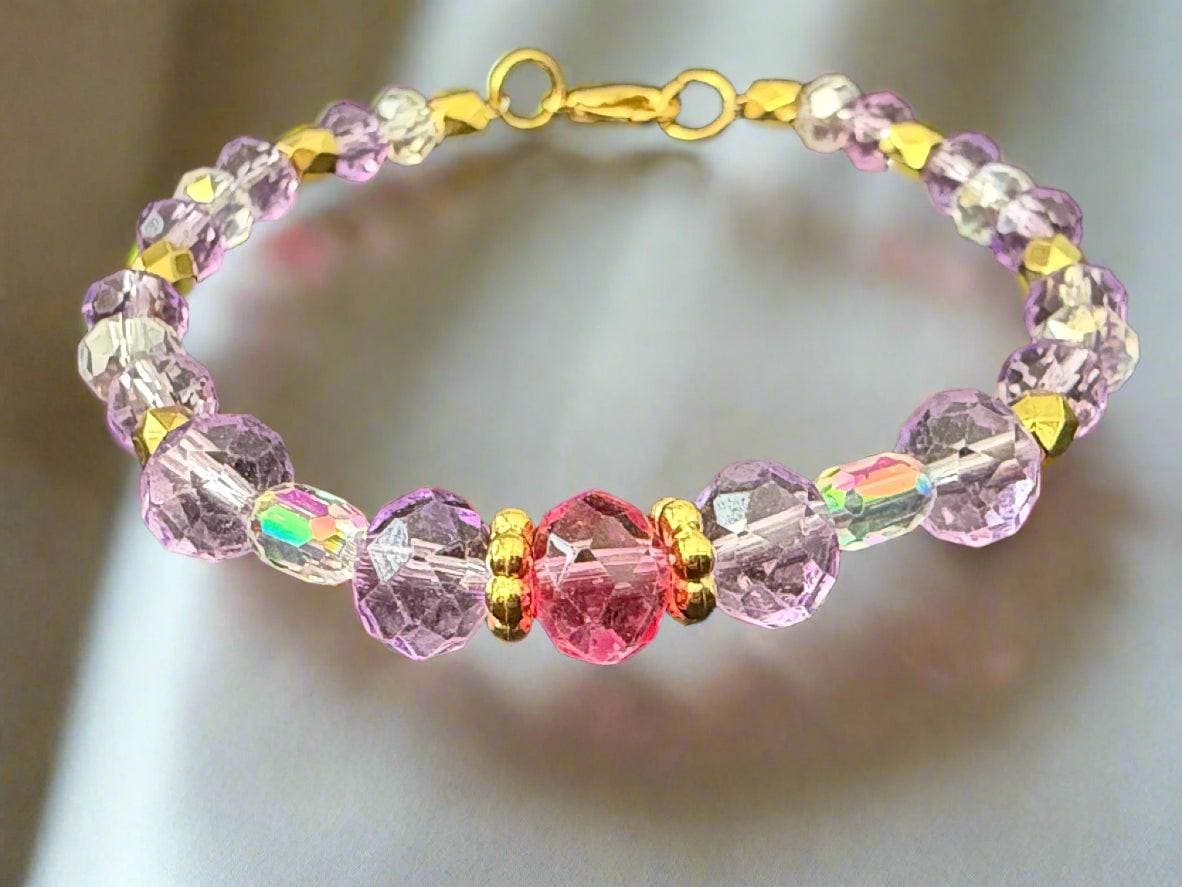 Beaded bracelet with pink, purple, and gold beads on a dark background
