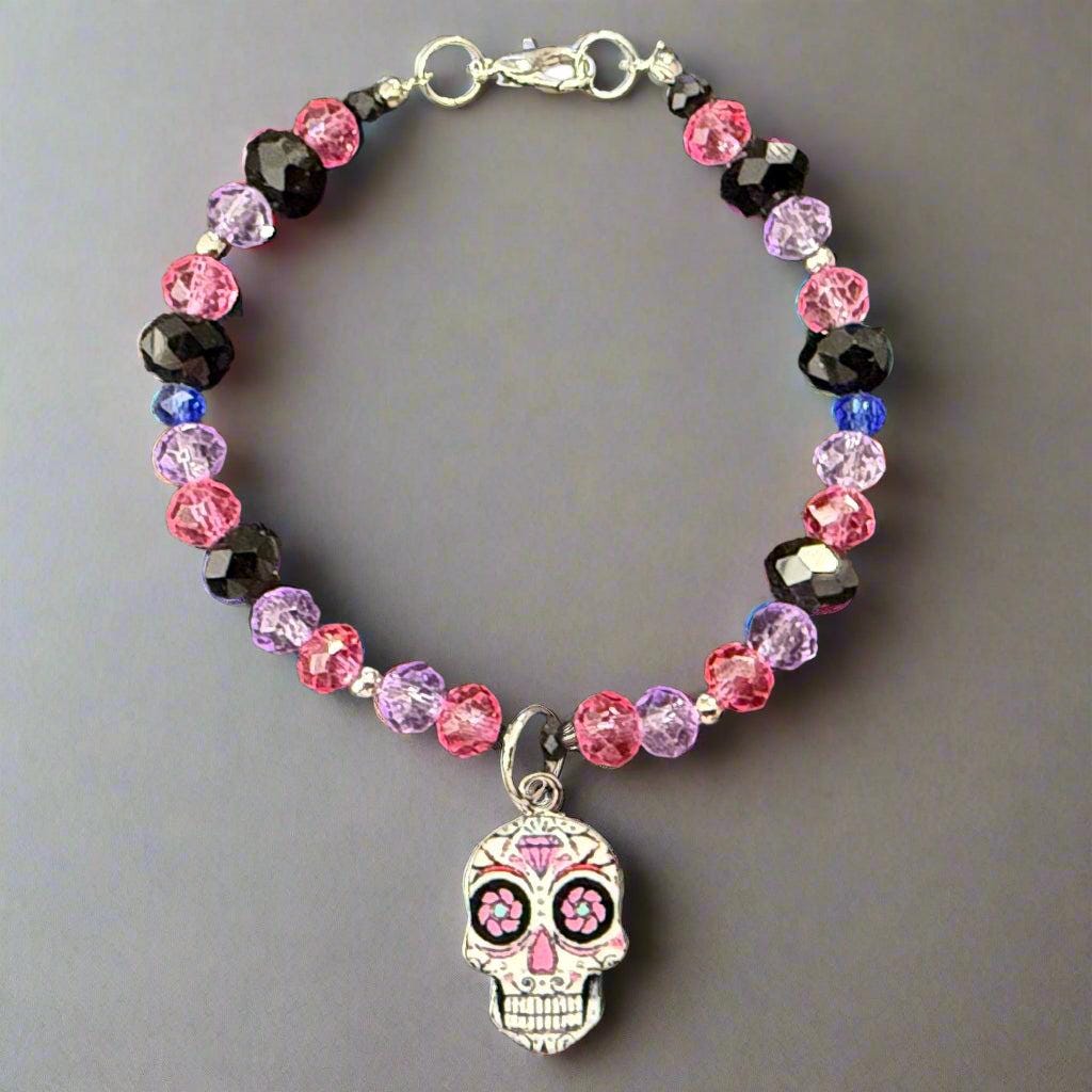 Beaded bracelet with a skull charm on a dark gray background