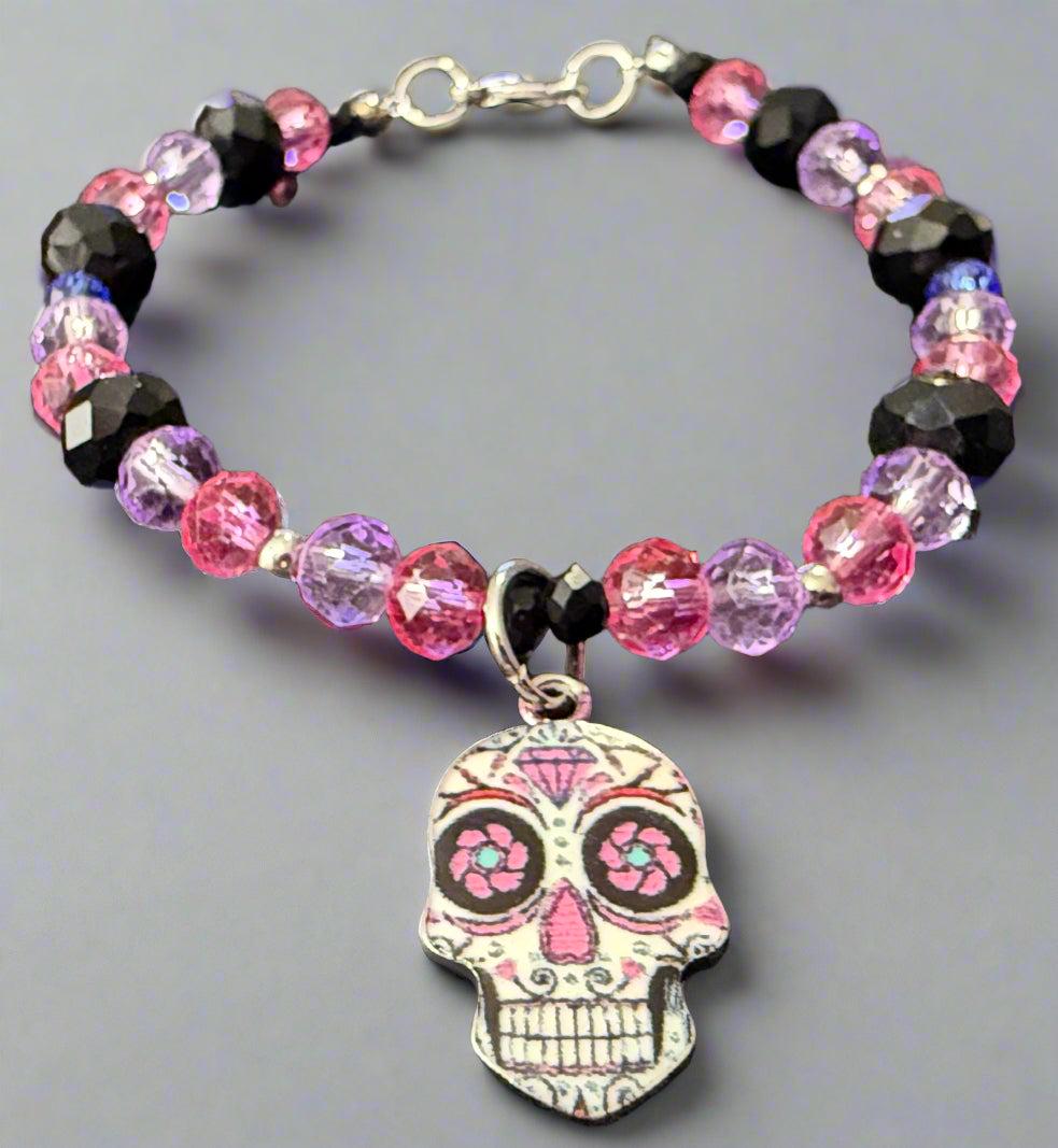 Bracelet with colorful beads and a skull charm on a dark background