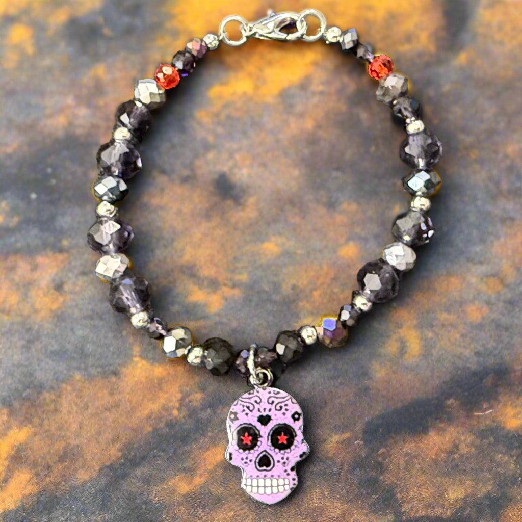 Beaded bracelet with a skull charm on a dark gray background