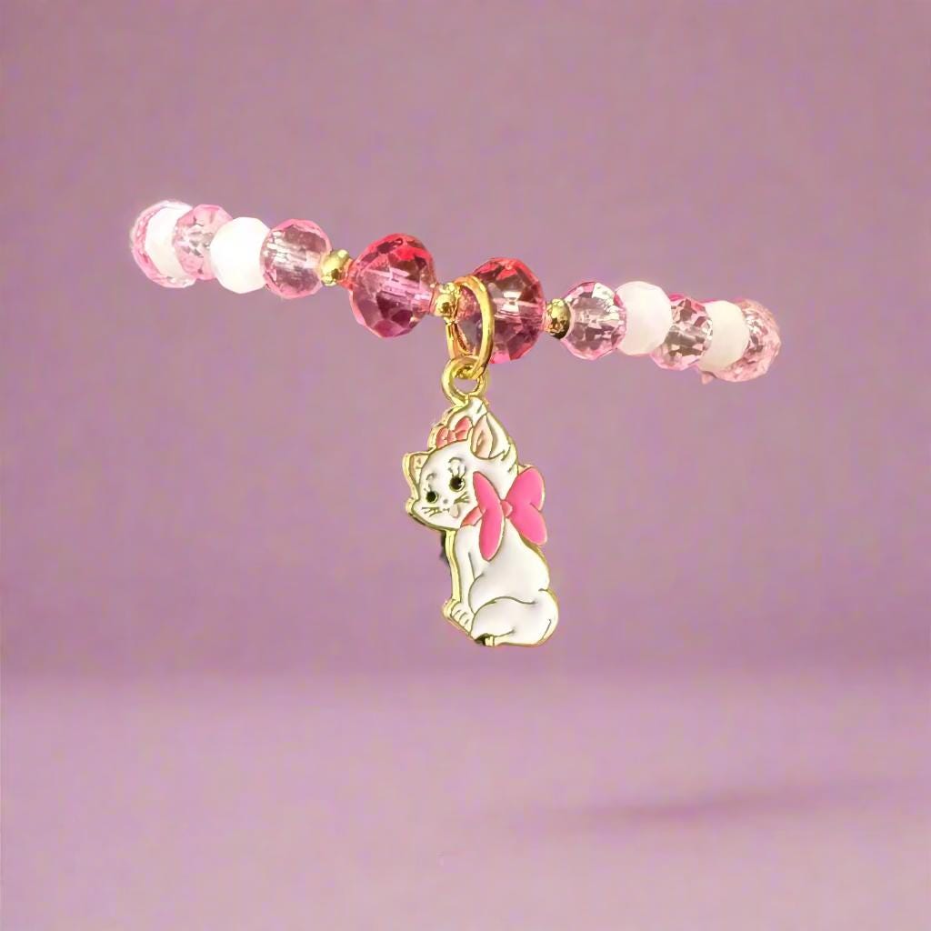 Bracelet with pink beads and a cat charm on a black mannequin hand.