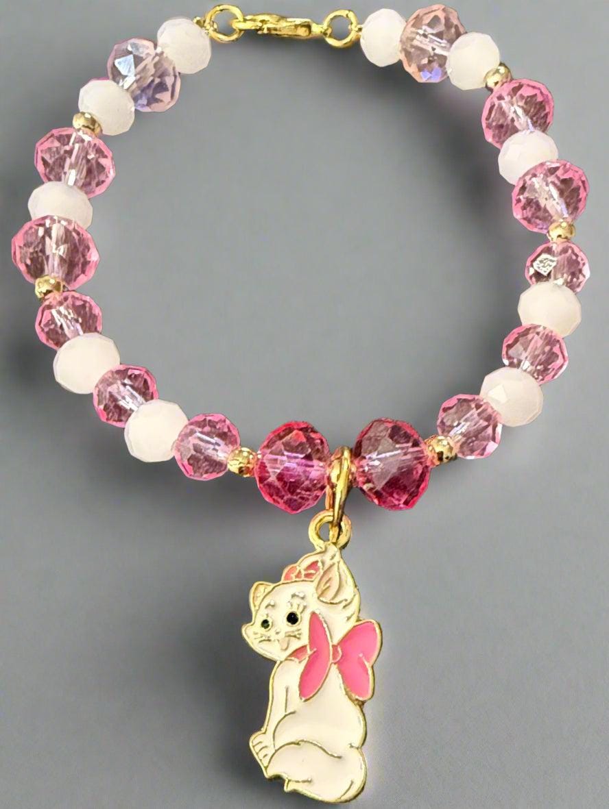 Bracelet with pink and white beads and a gold charm on a black background