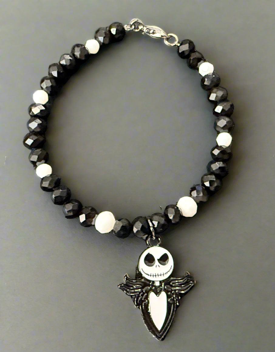 Bracelet with black beads and a Jack Skellington charm on a dark background
