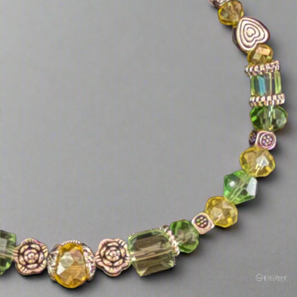 Beaded bracelet with green and yellow beads on a black textured background