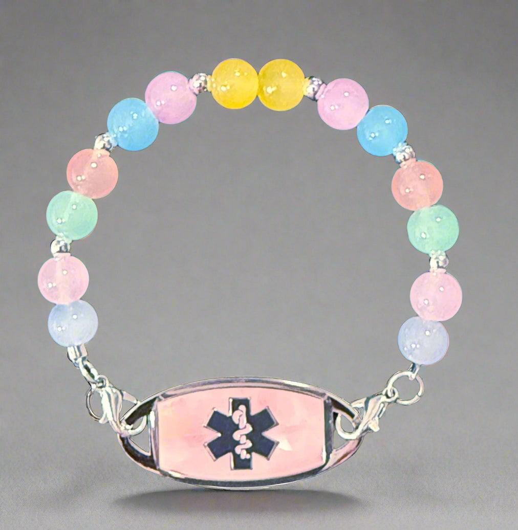Colorful beaded bracelet with an emergency medical symbol on a dark fabric background