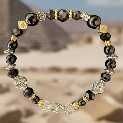 Bracelet with black beads and gold accents on a black background