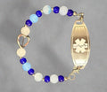 Bracelet with blue and white beads and a medical ID tag on a dark background