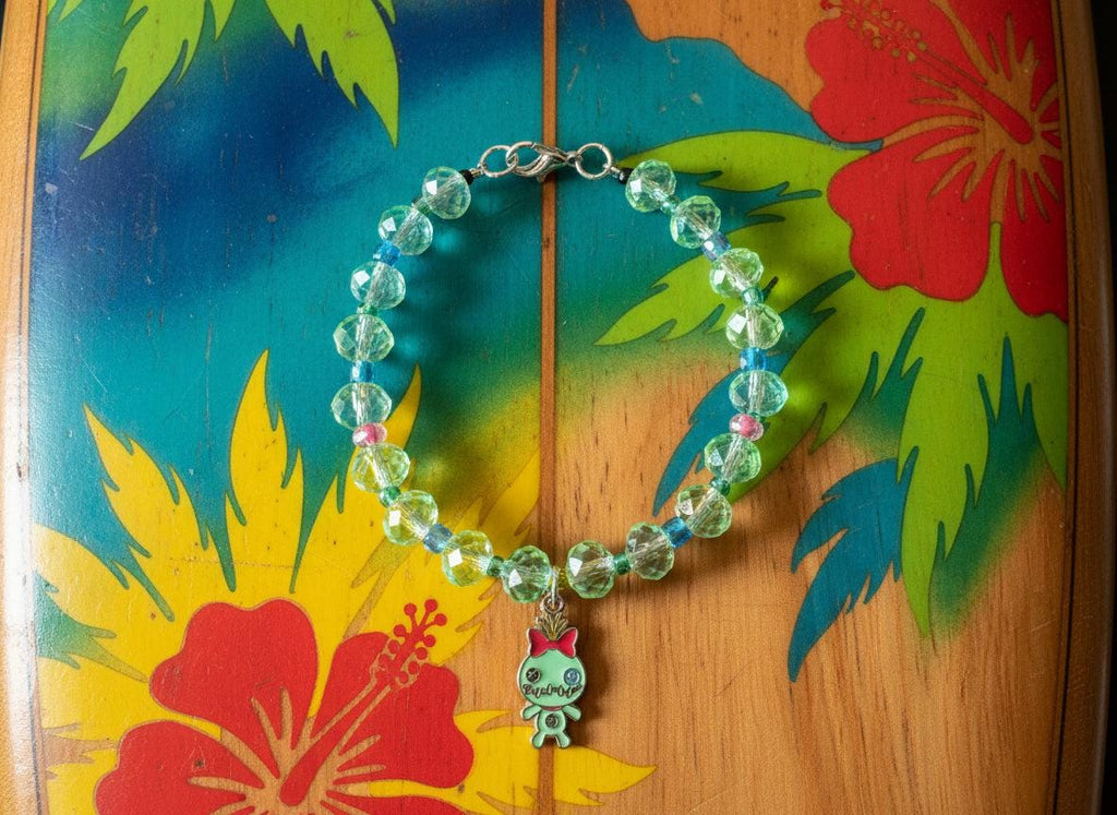 Beaded bracelet with a cat charm on a dark textured surface