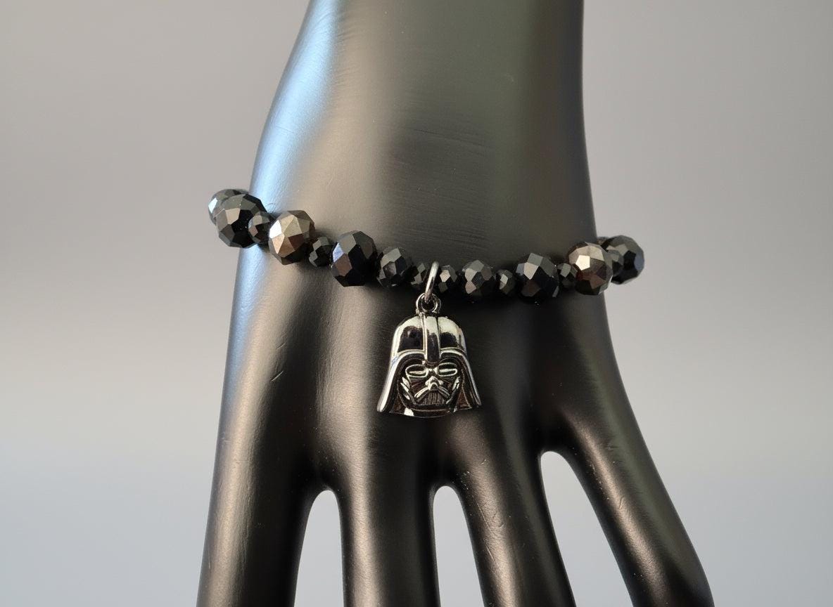 Black beaded bracelet with Darth Vader charm on a black mannequin hand.