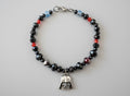 Beaded bracelet with a charm on a dark gray background