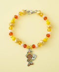 Beaded bracelet with a colorful charm on a dark textured background