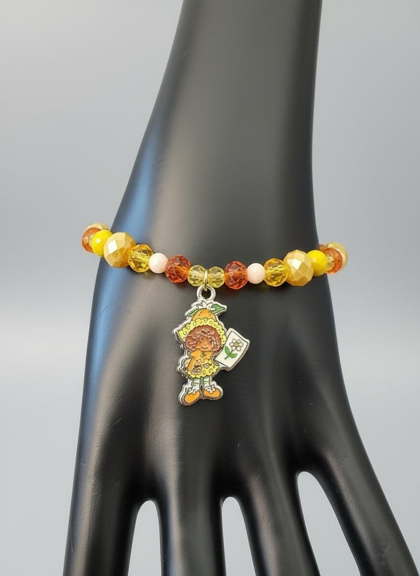 Colorful beaded bracelet with a turtle charm on a black mannequin hand.