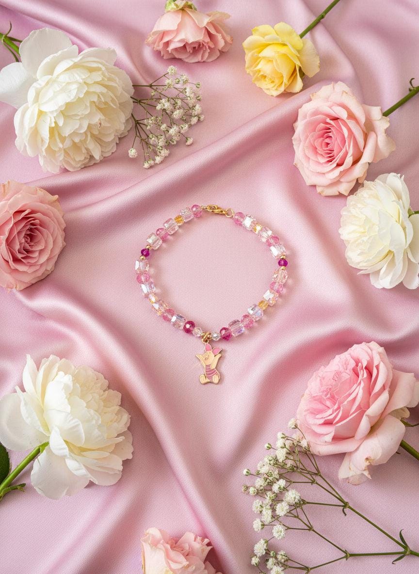 Colorful beaded bracelet with a goldfish charm on a black textured background