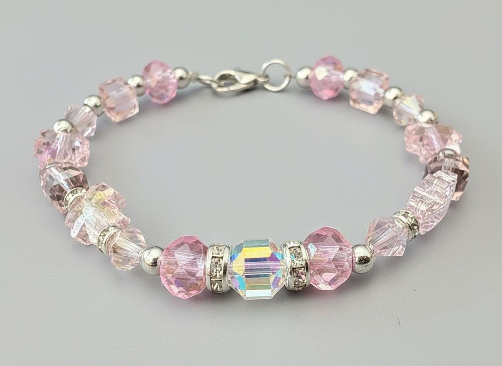 Beaded bracelet with pink and clear beads on a dark background