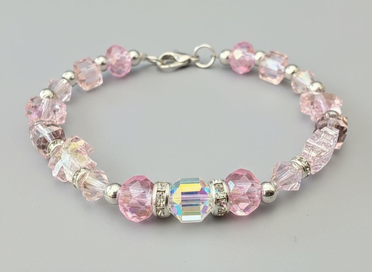 Beaded bracelet with pink and clear beads on a dark background