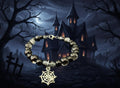 Bracelet with black beads and a spider web charm on a dark background