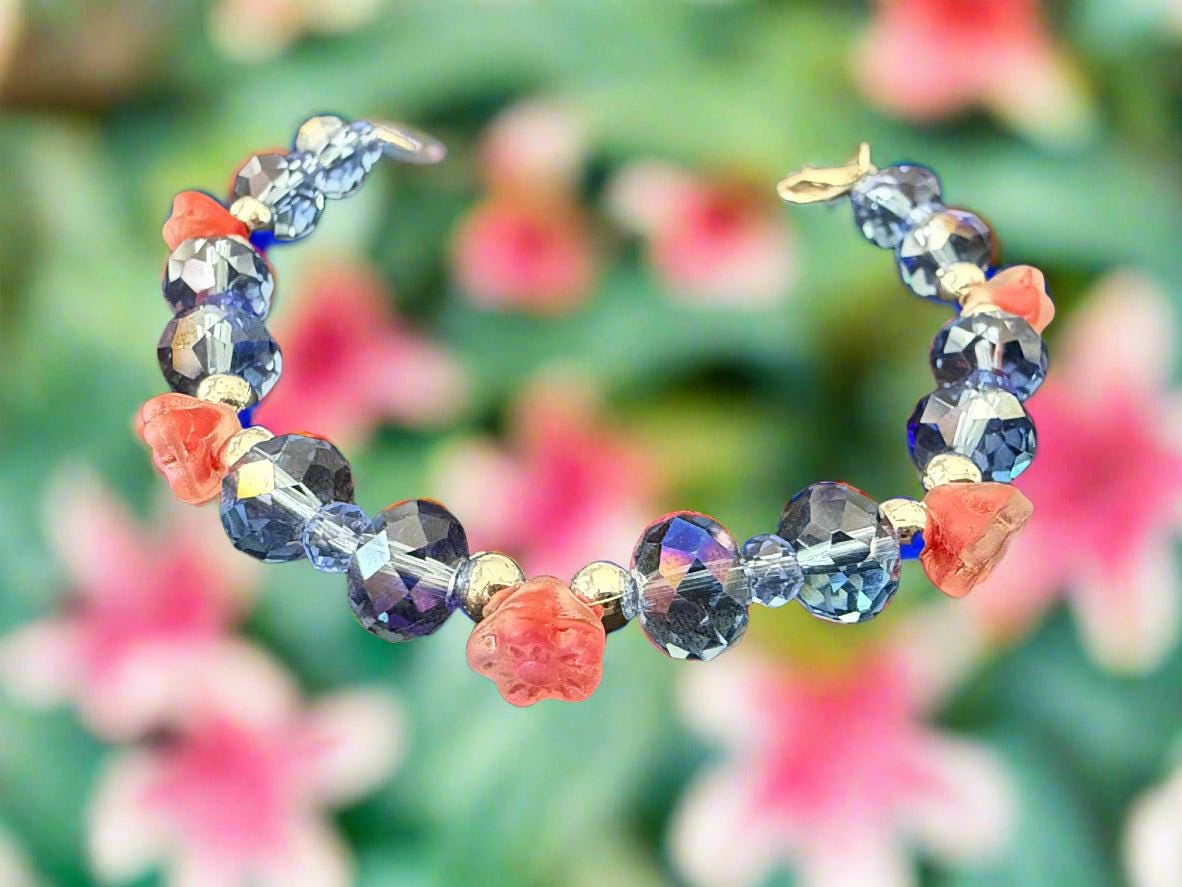 Beaded bracelet with blue, pink, and clear beads on a dark textured background