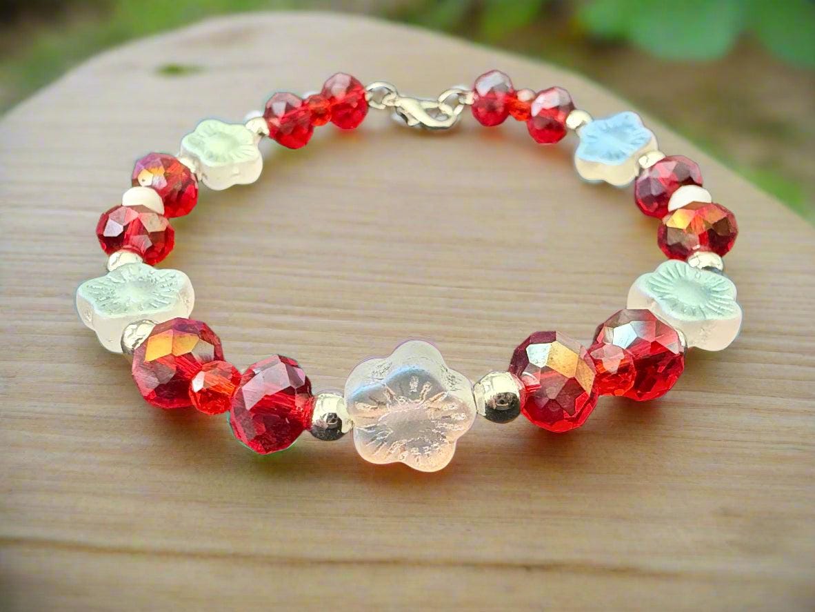 Bracelet with red and light blue beads on a dark background