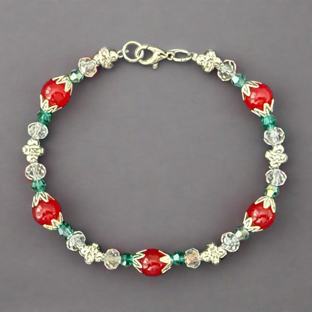 Beaded bracelet with red, green, and clear beads on a dark background