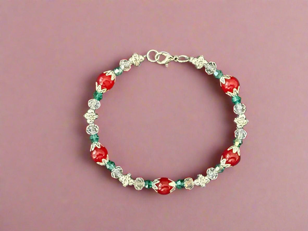Beaded bracelet with red, green, and clear beads on a dark background