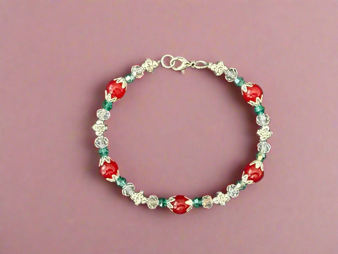 Beaded bracelet with red, green, and clear beads on a dark background