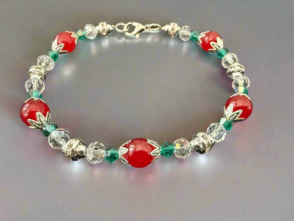 Beaded bracelet with red, clear, and green beads on a black background