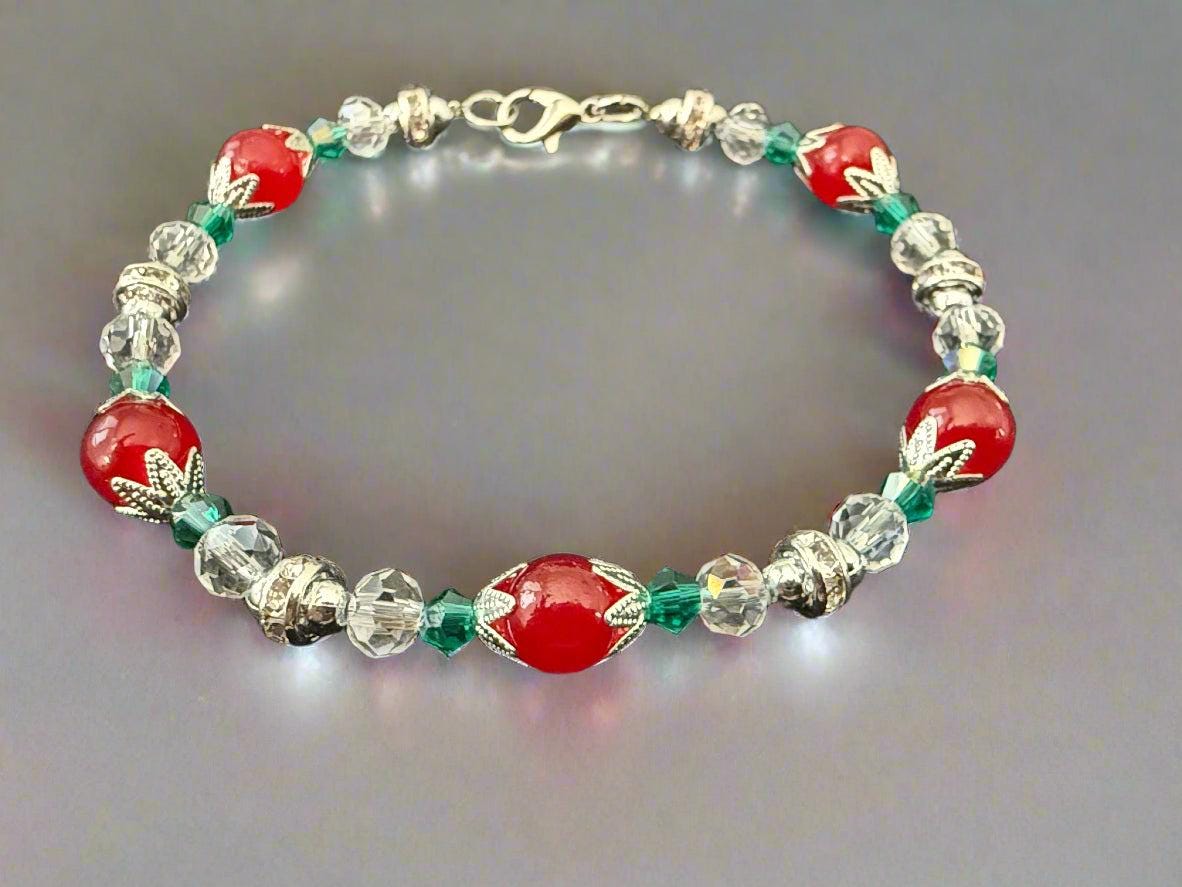 Beaded bracelet with red, clear, and green beads on a black background