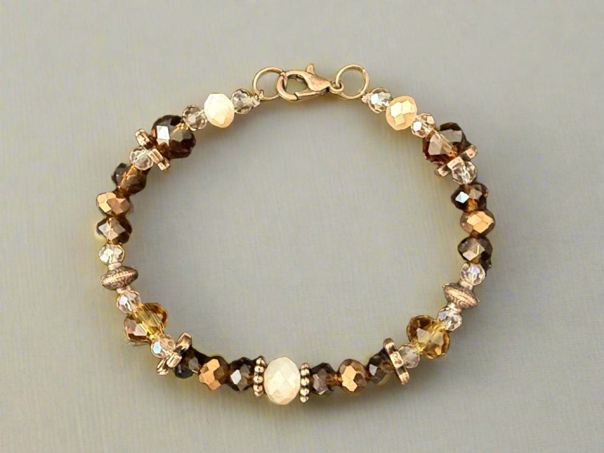 Beaded bracelet with gold and brown tones on a dark background