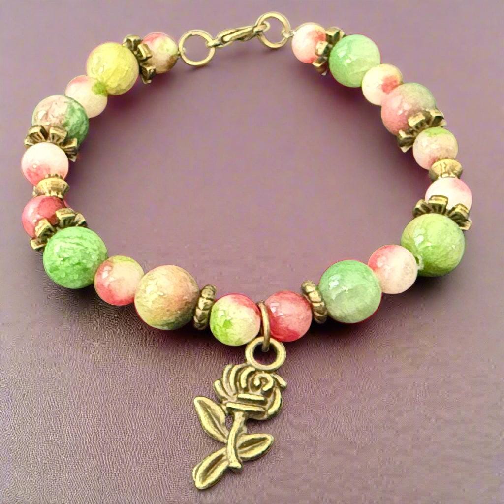 Beaded bracelet with a rose charm on a dark background