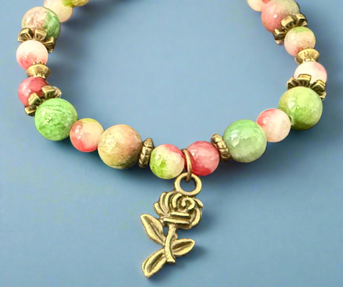 Beaded bracelet with a rose charm on a dark background