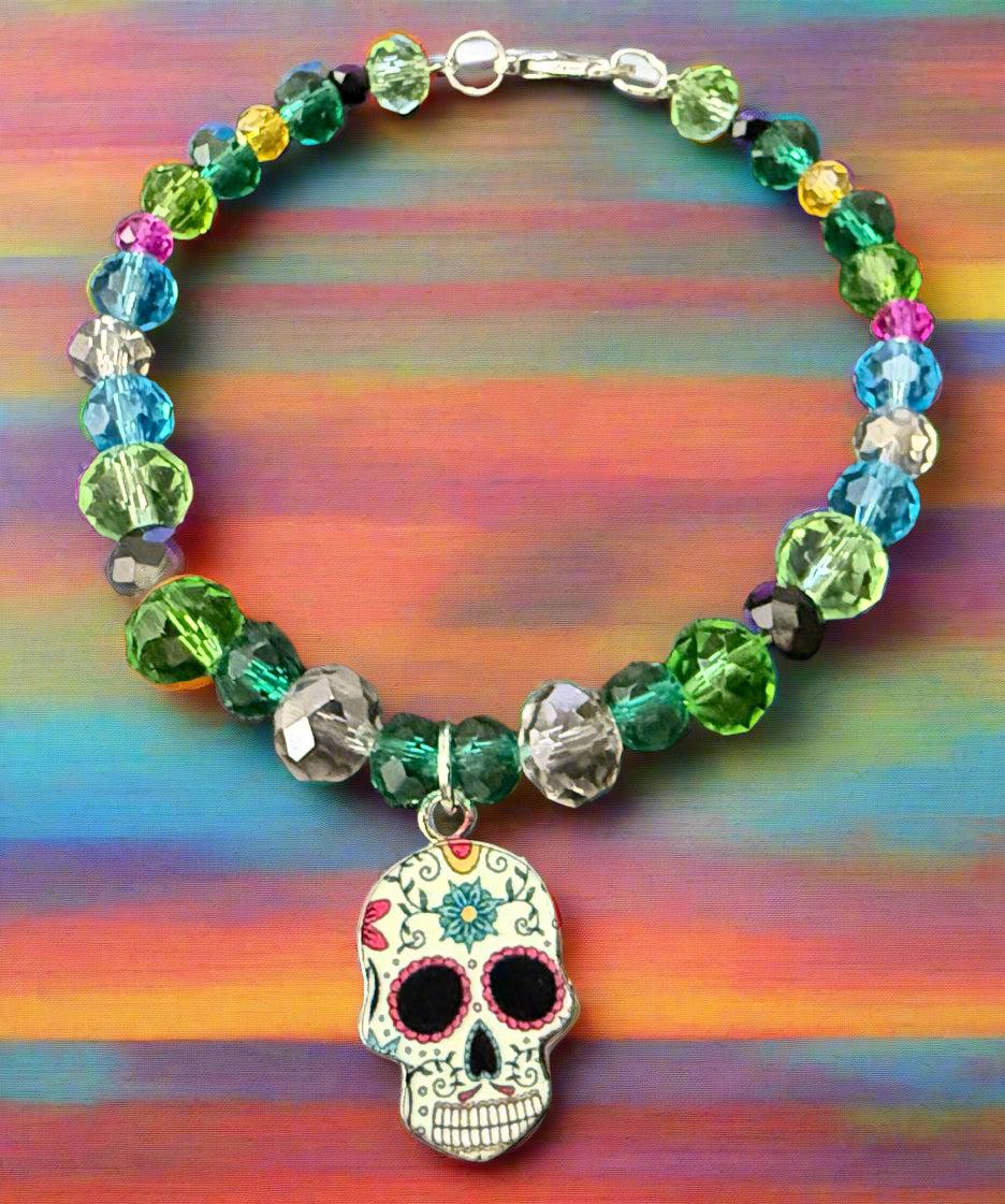 Colorful beaded bracelet with a skull charm on a dark surface