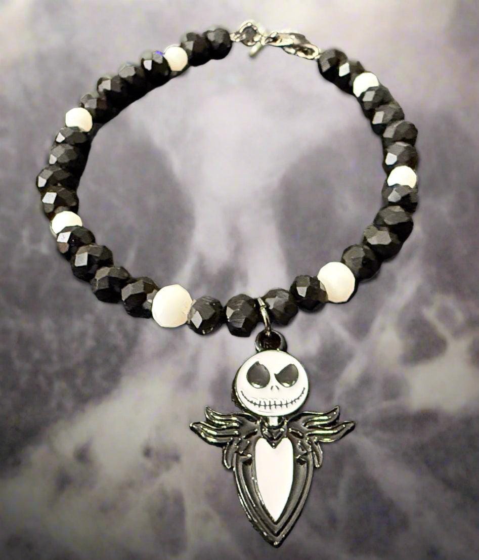 Black beaded bracelet with a skull charm on a dark textured surface