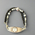 Bracelet with beaded design and medical ID tag on a dark background