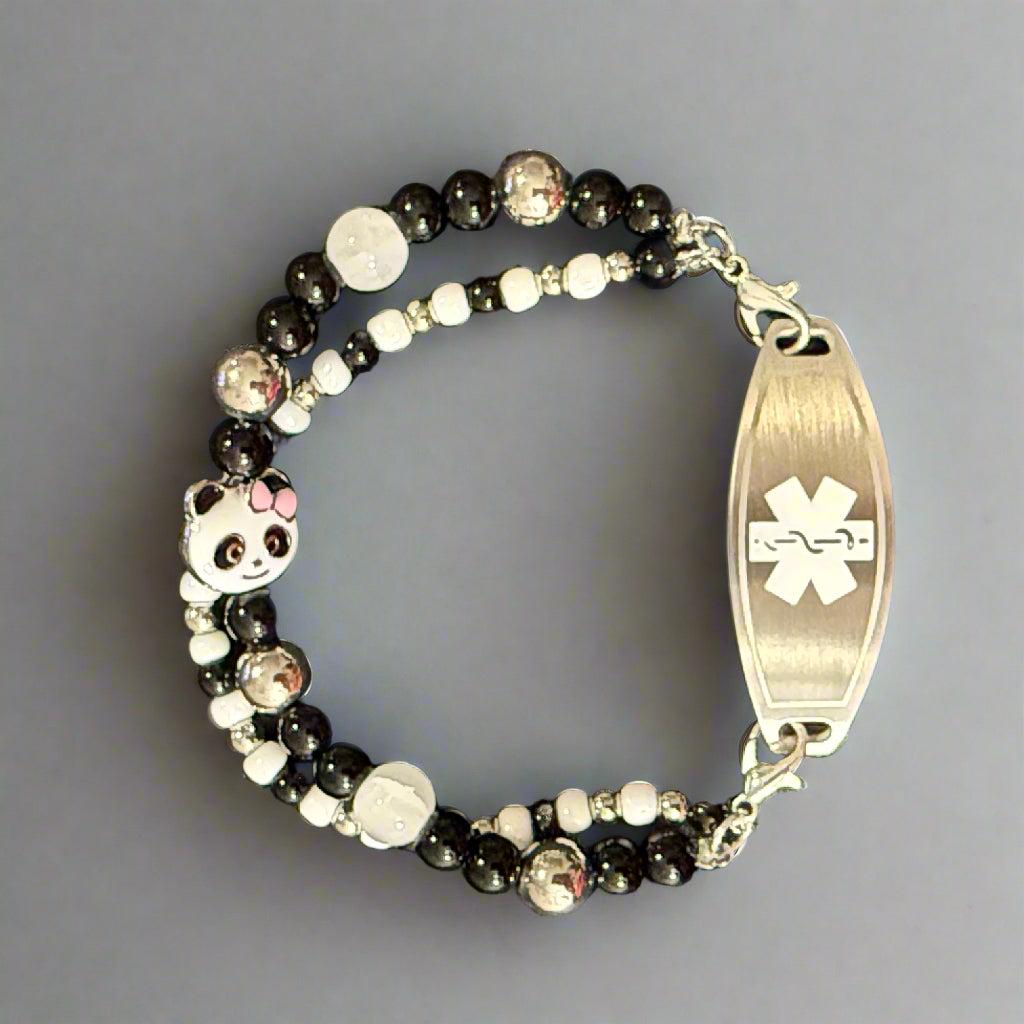 Beaded bracelet with panda charm and medical ID tag on a dark background