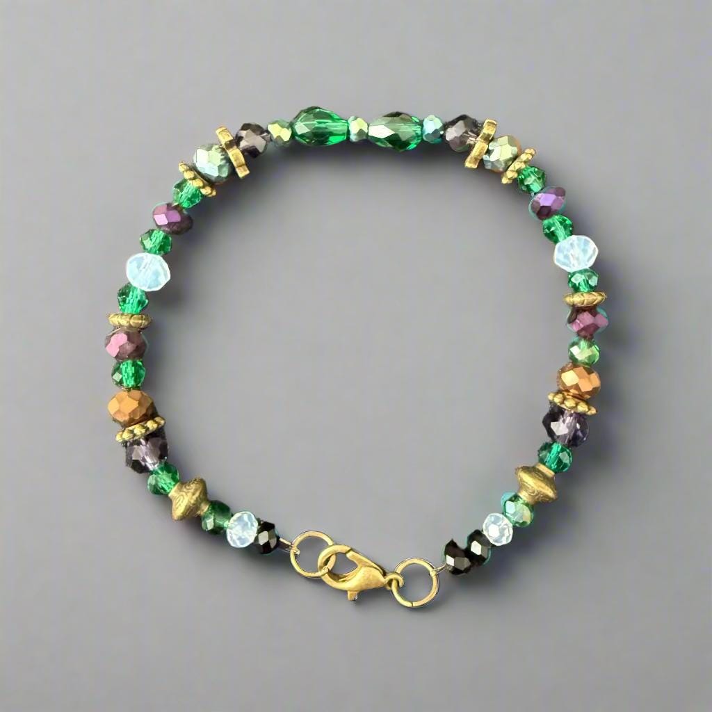 Multicolored beaded bracelet with a gold clasp on a gray textured background