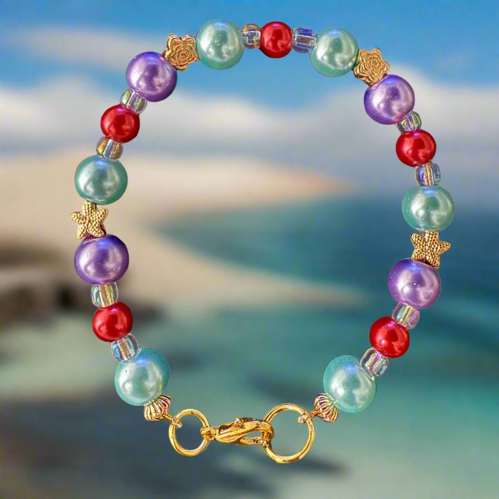 Colorful beaded bracelet with a gold clasp on a black textured background